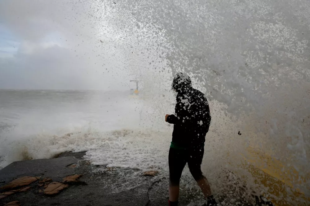 A woman is caught by a large wave at Blackrock diving tower during Storm Amy which brought severe weather, in Galway, Ireland, October 3, 2025. REUTERS/Clodagh Kilcoyne   TPX IMAGES OF THE DAY