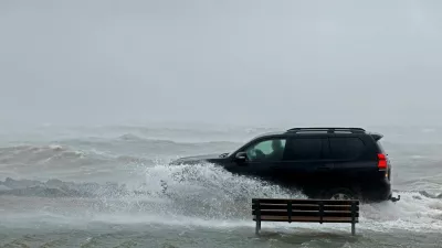 A car drives through a flooded park next to the sea during Storm Amy which brought severe weather, in Galway, Ireland, October 3, 2025. REUTERS/Clodagh Kilcoyne