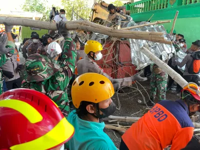 Rescuers clear debris from the site of a building that collapsed at an Islamic boarding school during the search for victims in Sidoarjo, East Java, Indonesia, Saturday, Oct. 4, 2025. (AP Photo/Trisnadi)