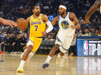 Oct 5, 2025; San Francisco, California, USA; Los Angeles Lakers guard Gabe Vincent (7) dribbles to the basket against Golden State Warriors guard Moses Moody (4) in the first quarter at Chase Center. Mandatory Credit: David Gonzales-Imagn Images