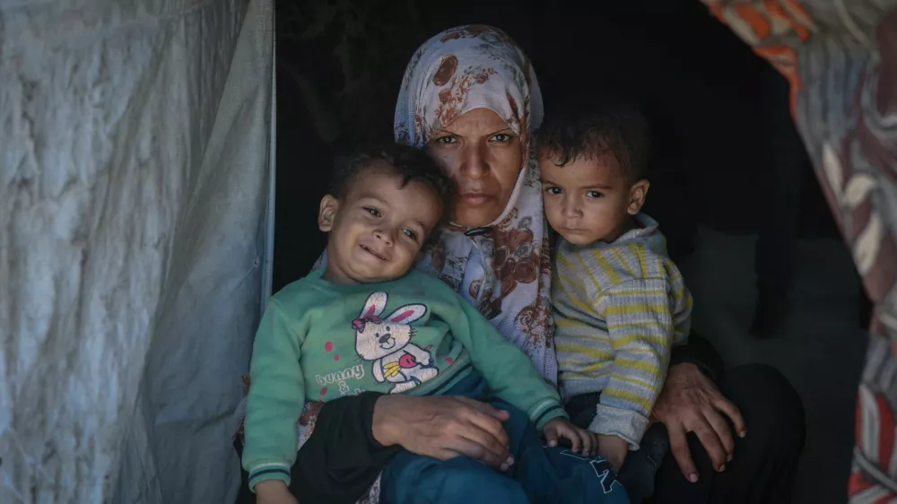 Displaced Palestinian mother Iman Abdel Halim Abu Mutlaq holds her twin sons Uday and Hamza Abu Odah at their tent where they shelter, in Mawasi area, in Khan Younis in the southern Gaza Strip, September 18, 2025. Uday and Hamza were born on 2 November 2023, less than four weeks after the Hamas attack that triggered Israel's devastating assault on Gaza that has defined and encompassed their brief lives. They have lost their home and lived in tents and on the street. Their father was killed seeking aid and two brothers were wounded. They have suffered constant hunger, frequent bouts of sickness and repeated episodes of terrifying bombardment. Their mother is frightened that the longer Israel's assault goes on, the more they - and the new generation of Gazans - will be scarred. "We are afraid this war will never stop, that it has a beginning and no end," she said. REUTERS/Ramadan Abed SEARCH "GAZA TWINS ODAH" FOR THIS STORY. SEARCH "WIDER IMAGE" FOR ALL STORIES. TPX IMAGES OF THE DAY