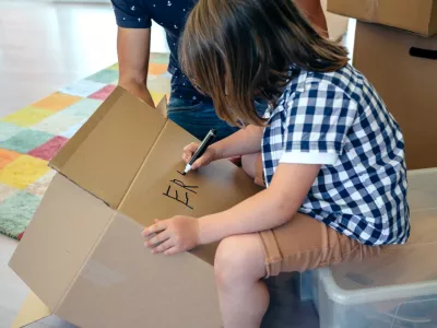 Deček, ki na škatlo zapisuje svoje ime. / Foto: Istock