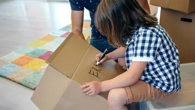 Deček, ki na škatlo zapisuje svoje ime. / Foto: Istock