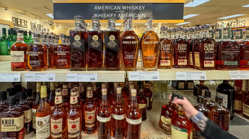 FILE PHOTO: A worker places bottles of American whiskey into a shopping cart to fill an order for a restaurant, at a Liquor Control Board of Ontario (LCBO) store in Hamilton, Ontario, Canada February 2, 2025. REUTERS/Carlos Osorio/File Photo