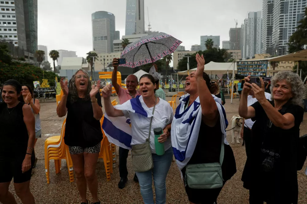 People celebrate after U.S. President Donald Trump announced that Israel and Hamas agreed on the first phase of a Gaza ceasefire, at the "Hostages square", in Tel Aviv, Israel, October 9, 2025. REUTERS/Ronen Zvulun