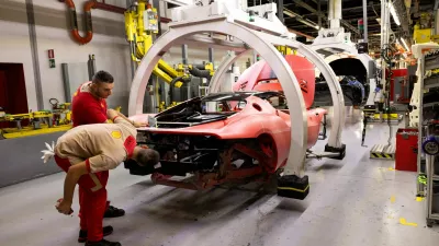 FILE PHOTO: Ferrari workers inspect a supercar chassis inside the company's factory in Maranello, Italy, October 2, 2025. REUTERS/Remo Casilli/File Photo