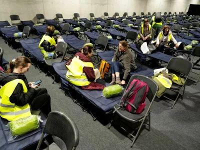 FILE PHOTO: Volunteers who participate as evacuees during a drill in case of military conflict sit on chairs and beds in the evacuation center set up in the athletics hall in Kaunas, Lithuania October 7, 2025. REUTERS/Ints Kalnins/File Photo
