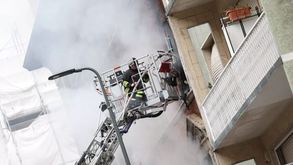 Firefighters spray water at a house on fire following an explosion in the centre of Milan, Italy, May 11, 2023. REUTERS/Claudia Greco