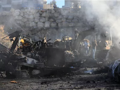 People gather at a site that sold heavy machinery, where a large number of vehicles were destroyed in Israeli airstrikes, in the southern village of Msayleh, Lebanon, Saturday, Oct. 11, 2025. (AP Photo/Mohammed Zaatari)