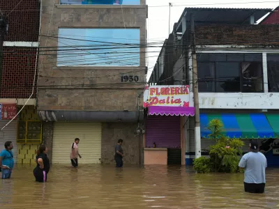 People wade through a flooded street after torrential rains that caused an overflow of rivers in Poza Rica, Veracruz state, Mexico, October 10, 2025. REUTERS/Rolando Ramos   TPX IMAGES OF THE DAY