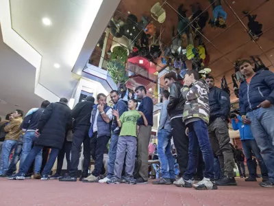 ﻿People line up for their meal in the initial reception center for asylum seekers in Halle/Saale, Germany, Friday, Oct. 16, 2015. The center in a former hotel has capacity for around 700 refugees. (AP Photo/Jens Meyer)