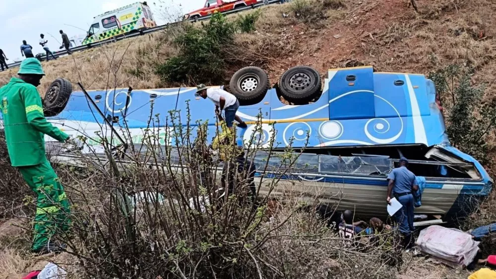 In this photo made available by the South African Department of Transport and Community Safety, Police officers and emergency rescue workers search for victims from a bus lying upside down in the embankment, in Louis Trichardt, South Africa, Sunday, Oct. 12, 2025. (South African Department of Transport and Community Safety via AP)