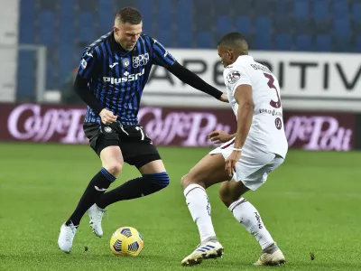 Atalanta's Josip Ilicic, left, takes on Torino's Gleison Bremer during the Serie A soccer match between Torino and Atalanta, at the Gewiss Stadium in bergamo, Italy, Saturday, Feb. 6, 2021. (Gianluigi Checchi/LaPresse via AP)