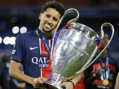 Soccer Football - Champions League - Final - Paris St Germain v Inter Milan - Allianz Arena, Munich, Germany - May 31, 2025 Paris St Germain's Marquinhos celebrates with the trophy after winning the Champions League REUTERS/Peter Cziborra