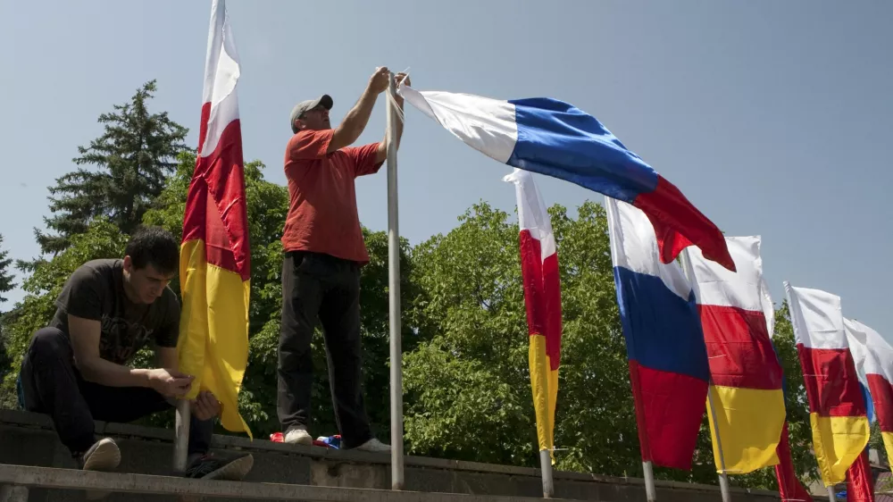 ﻿Men attach flags of South Ossetia and Russia during the preparations for an oath of allegiance military ceremony in Tskhinvali, the capital of the breakaway region of South Ossetia, Georgia, July 5, 2015. President Vladimir Putin signed a treaty with Georgia's rebel South Ossetia region on March 18 that almost completely integrates it with Russia, alarming Georgia and the West a year after Moscow took over Crimea. Russia won a five-day war with Georgia in 2008 over the fate of South Ossetia and another rebel region, Abkhazia. It formally recognizes both regions as independent states and signed a similar treaty with Abkhazia last year. Picture taken July 5, 2015. REUTERS/Kazbek Basaev