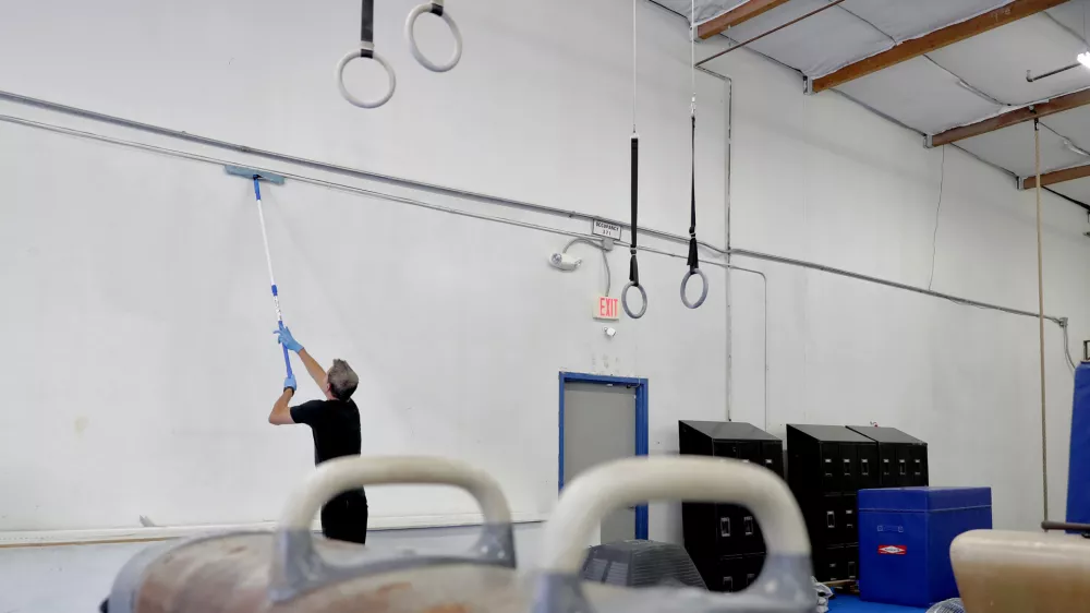 ﻿Southwest Gymnastics Training Center owner Brock Anstine cleans walls in his gym Monday, March 23, 2020, in Tempe, Ariz. Anstine, in compliance with CDC guidelines to help slow the spread of the COVID-19 coronavirus, has closed his gym and is paying his staff to deep cleans and paint the facility during their shut down. (AP Photo/Matt York)