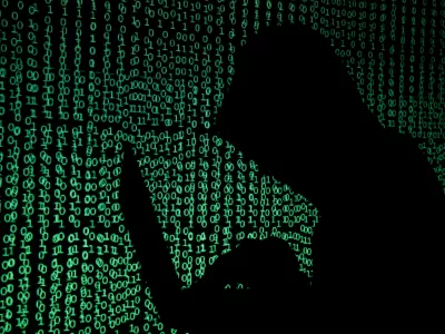 ﻿A hooded man holds a laptop computer as cyber code is projected on him in this illustration picture taken on May 13, 2017. Capitalizing on spying tools believed to have been developed by the U.S. National Security Agency, hackers staged a cyber assault with a self-spreading malware that has infected tens of thousands of computers in nearly 100 countries. REUTERS/Kacper Pempel/Illustration