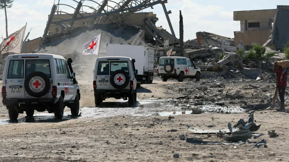 Red Cross vehicles escort a truck transporting the bodies of Palestinians who had been held in Israel during the war, amid a ceasefire between Israel and Hamas, in Khan Younis in the southern Gaza Strip, October 14, 2025. REUTERS/Ramadan Abed   TPX IMAGES OF THE DAY