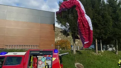 Jadralna padalka je obvisela na smreki. 