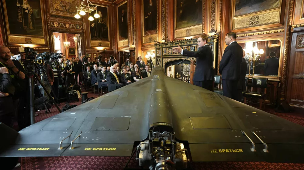 Britain's former security minister Tom Tugendhat, second right, and Polish foreign minister Radek Sikorski speak in front of a downed Russian's army Shahed-136 attack drone, during a press conference organised by United Against Nuclear Iran (UANI), in Speaker's Court at the House of Commons, Westminster, London, Tuesday, Oct. 14, 2025. (Stefan Rousseau/PA via AP)