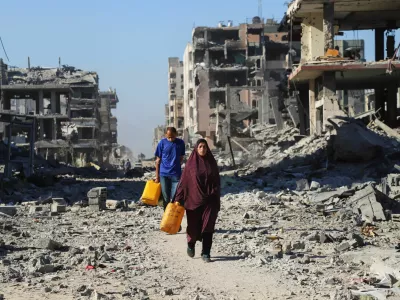 Palestinians walk past the rubble of destroyed buildings, amid a ceasefire between Israel and Hamas, in Gaza City, October 15, 2025. REUTERS/Ebrahim Hajjaj / Foto: Ebrahim Hajjaj