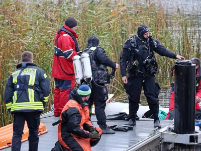 14 October 2025, Mecklenburg-Western Pomerania, Guestrow: Divers are preparing to search for missing eight-year-old Fabian at the Inselsee lake. A child's body has been found after a four-day search for a missing 8-year-old in northern Germany, with police suspecting a criminal offence in the case. Photo: Bernd Wüstneck/dpa
