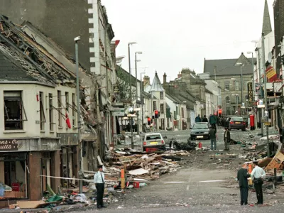 FILE - Royal Ulster Constabulary Police officers stand on Market Street, the scene of a car bombing in the centre of Omagh, Co Tyrone, 72 miles west of Belfast, Northern Ireland, on Aug. 15, 1998. (AP Photo/Paul McErlane, File)