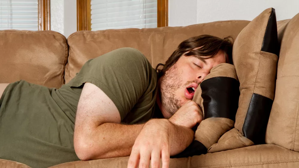 Malce pretirana slika mladeniča, ki še vedno živi doma, dela, vendar ne prispeva za račune. / Foto: Istock