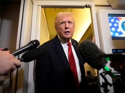 President Donald Trump speaks to reporters aboard Air Force One, Sunday, Oct. 19, 2025, en route to Joint Base Andrews, Md., as he returns from a trip to Florida. (AP Photo/Mark Schiefelbein)