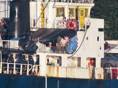 Some the estimated 490 people thought to be Tamil migrants aboard the ship MV Sun Sea peer out from underneath a tarp after Canadian Border officials and police brought the ship into Canadian Forces Base Esquimalt in Colwood, British Columbia on Vancouver Island August 13, 2010. Authorities intercepted and boarded the ship after it entered Canadian waters.     REUTERS/Andy Clark   (CANADA - Tags: CIVIL UNREST SOCIETY POLITICS IMAGES OF THE DAY)