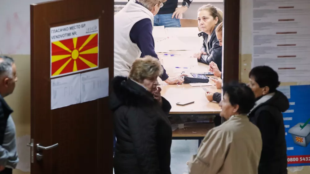People wait to enter a polling station prior voting for the local elections, in Skopje, North Macedonia, on Sunday, Oct. 19, 2025. (AP Photo/Boris Grdanoski)