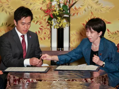 Leader of Japan's ruling Liberal Democratic Party (LDP) Sanae Takaichi and Hirofumi Yoshimura, leader the Japan Innovation Party, known as Ishin, sign a document on the coalition deal during a meeting at Japan's National Diet Building in Tokyo, Japan, October 20, 2025. REUTERS/Kim Kyung-Hoon