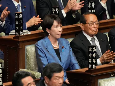 Sanae Takaichi, center, leader of the ruling Liberal Democratic Party, reacts as she was elected as Japan's new prime minister during the extraordinary session of the lower house, in Tokyo, Japan, Tuesday, Oct. 21, 2025.(AP Photo/Eugene Hoshiko)