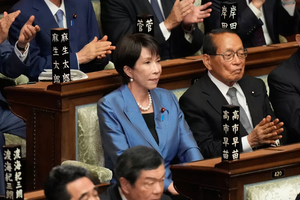Sanae Takaichi, center, leader of the ruling Liberal Democratic Party, reacts as she was elected as Japan's new prime minister during the extraordinary session of the lower house, in Tokyo, Japan, Tuesday, Oct. 21, 2025.(AP Photo/Eugene Hoshiko)