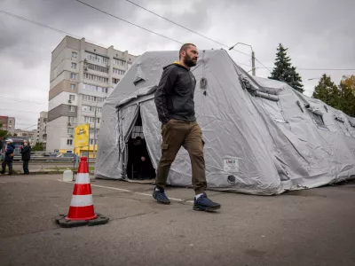 A man passes by one of the heated tents called points of invincibility, government-built help stations, during a total blackout following Russian air attacks on energy objects in Chernihiv, Ukraine, Tuesday, Oct. 21, 2025. (AP Photo/Dan Bashakov)