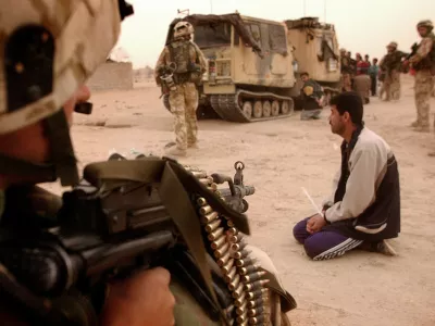 Iraški vojak pred strojnico ameriškega komandosa med invazijo leta 2003. / Foto: Profimedia