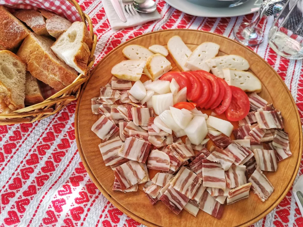 Slanina, paradižnik, sir, čebula, ob smetani kot tipična hladna predjed / Foto: Miha First