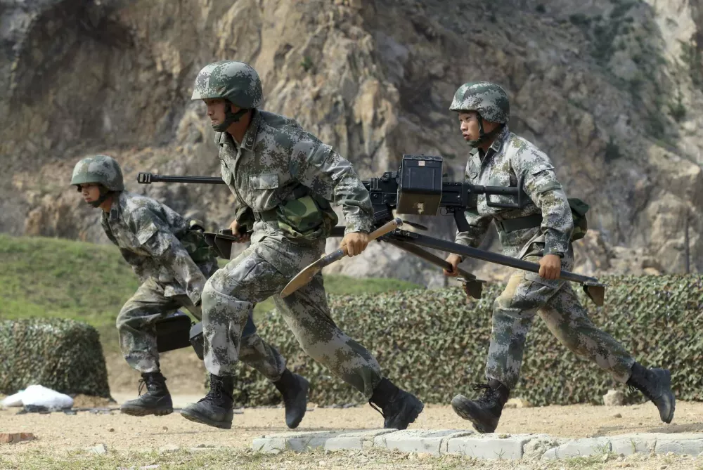 ﻿Members of People's Liberation Army (PLA) coastal defence force carry a machine gun during a drill to mark the upcoming 87th Army Day at a military base in Qingdao, Shandong province July 29, 2014. The PLA Army Day falls on August 1 every year. Chinese President Xi Jinping has pledged to strike hard against graft in the military, urging soldiers to banish corrupt practices and ensure their loyalty to the ruling Communist Party, state media reported on Friday. Picture taken July 29, 2014. REUTERS/Stringer (CHINA - Tags: MILITARY POLITICS ANNIVERSARY) CHINA OUT. NO COMMERCIAL OR EDITORIAL SALES IN CHINA / Foto: China Stringer Network