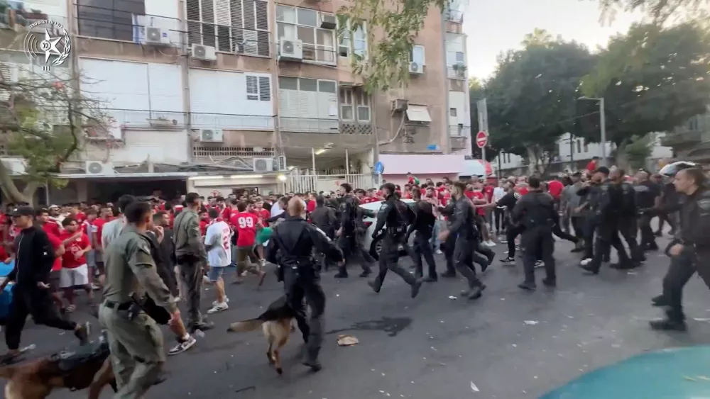 Israeli law enforcement personnel disperse a crowd of football club supporters outside Bloomfield Stadium after an Israeli Premier League match between Hapoel and Maccabi was cancelled due to what Israel Police said was public disorder and violent riots, in Tel Aviv, Israel in this screengrab from video released October 19, 2025.  Israel Police/Handout via REUTERS  THIS IMAGE HAS BEEN SUPPLIED BY A THIRD PARTY VERIFICATION LINES: - Road layout, business signages and trees matched file images - Date could not be independently verified
