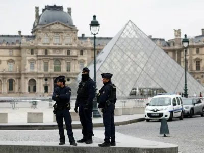 Police officers stand near the pyramid of the Louvre museum after reports of a robbery, in Paris, France, October 19, 2025. REUTERS/Gonzalo Fuentes   TPX IMAGES OF THE DAY