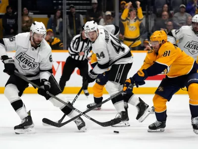 Los Angeles Kings defenseman Joel Edmundson (6) and Nashville Predators center Jonathan Marchessault (81) battle for the puck during overtime of an NHL hockey game Saturday, Oct. 25, 2025, in Nashville, Tenn. (AP Photo/Mark Humphrey)