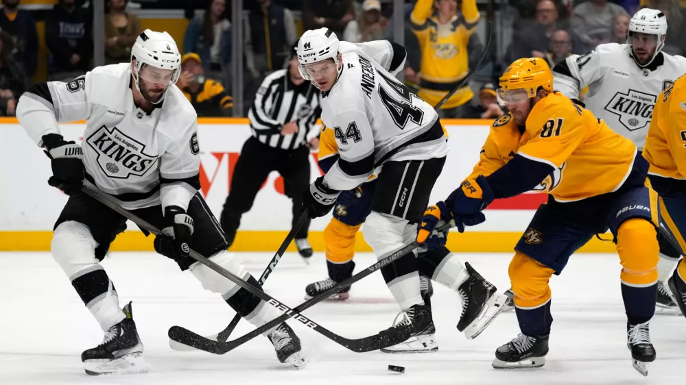 Los Angeles Kings defenseman Joel Edmundson (6) and Nashville Predators center Jonathan Marchessault (81) battle for the puck during overtime of an NHL hockey game Saturday, Oct. 25, 2025, in Nashville, Tenn. (AP Photo/Mark Humphrey)