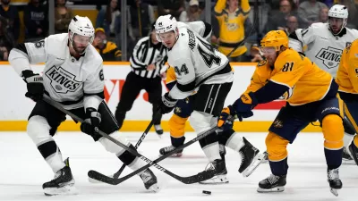 Los Angeles Kings defenseman Joel Edmundson (6) and Nashville Predators center Jonathan Marchessault (81) battle for the puck during overtime of an NHL hockey game Saturday, Oct. 25, 2025, in Nashville, Tenn. (AP Photo/Mark Humphrey)