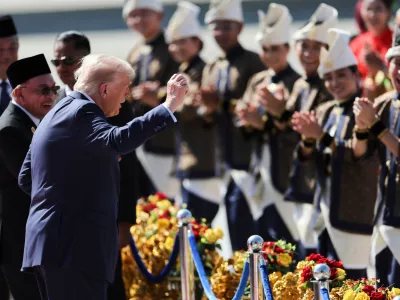 U.S. President Donald Trump reacts to dancing performers during a welcoming ceremony after arriving at Kuala Lumpur International Airport, to attend the 47th Association of Southeast Asian Nations (ASEAN) summit in Kuala Lumpur, Malaysia, Sunday, Oct. 26, 2025. (Hasnoor Hussain/Pool Photo via AP)