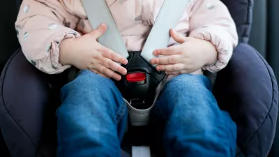 Hands of a little girl lie on the seat belt buckle of a child seat. Close-up,Image: 538187485, License: Royalty-free, Restrictions:, Model Release: yes