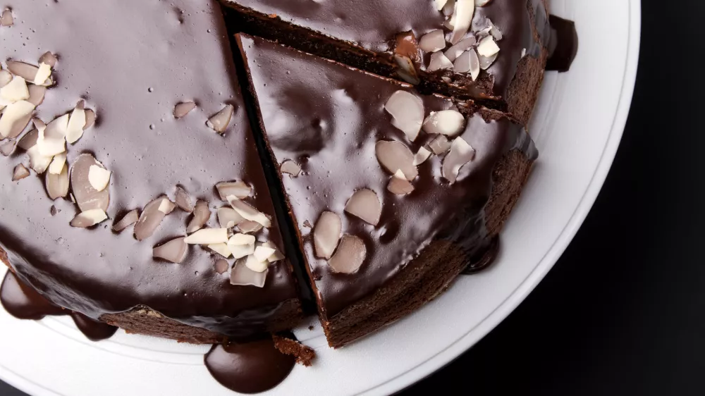 Chocolate cake with chocolate frosting on black background, top view