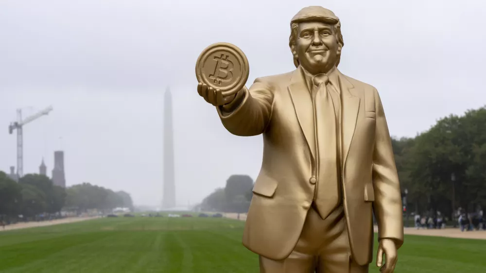 A statue of President Donald Trump holding a bitcoin in recognition of his support for cryptocurrency is displayed on the National Mall with the Washington Monument behind, Wednesday, Sept. 17, 2025, in Washington. (AP Photo/Alex Brandon)
