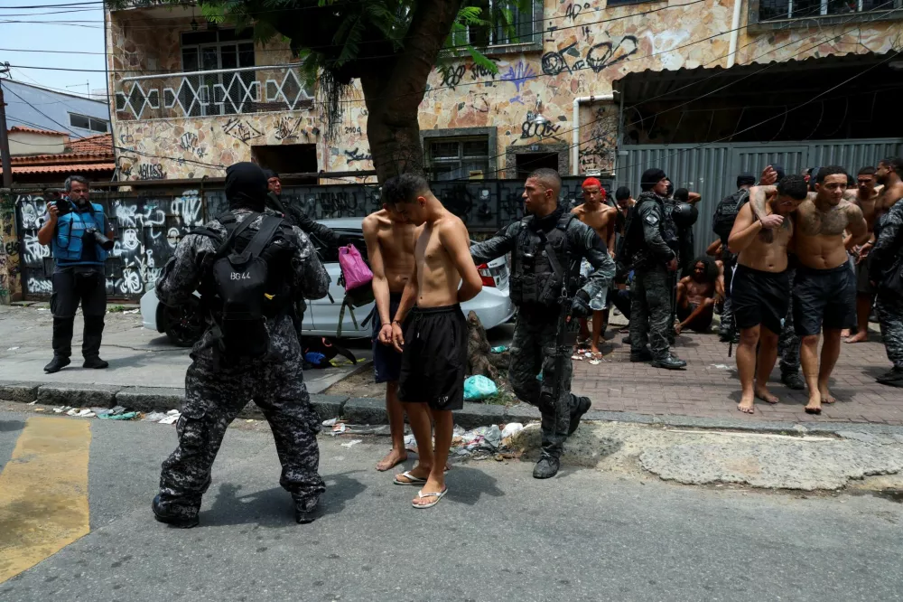 Members of the military police special unit detain suspected drug dealers during a police operation against drug trafficking at the favela do Penha, in Rio de Janeiro, Brazil October 28, 2025. REUTERS/Aline Massuca