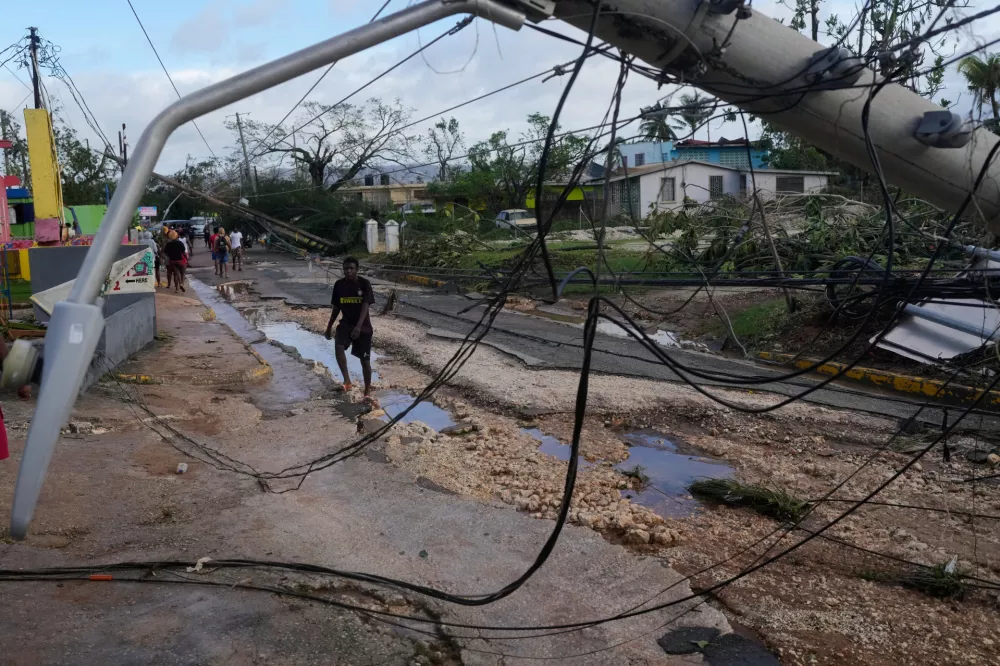 Residents walk through Santa Cruz, Jamaica, Wednesday, Oct. 29, 2025, after Hurricane Melissa passed. (AP Photo/Matias Delacroix)