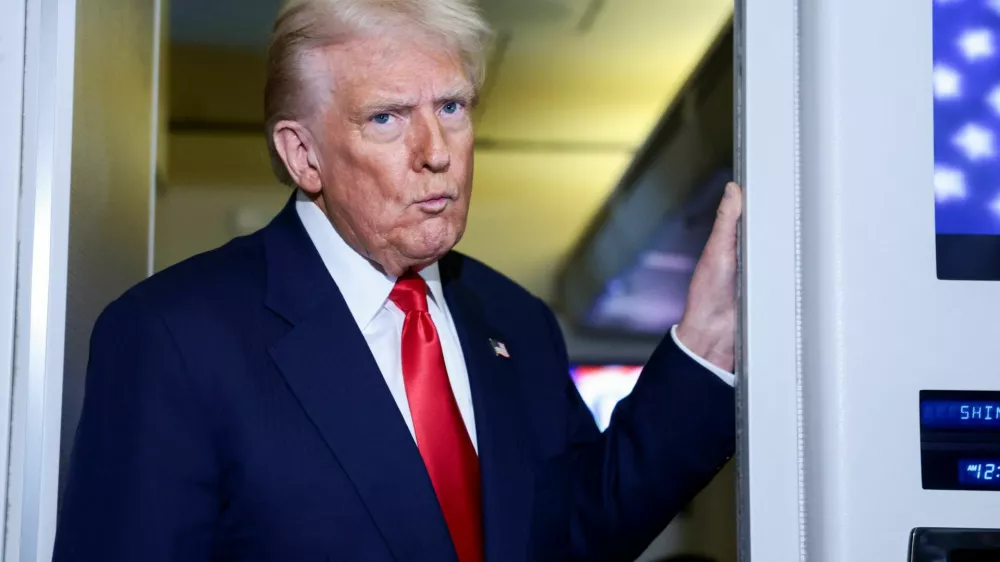 U.S. President Donald Trump reacts while speaking to members of the media on board Air Force One en route to the U.S., October 30, 2025. REUTERS/Evelyn Hockstein